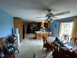 Pre-remodel kitchen in Akron, NY, showcasing original cabinets, old flooring, and traditional layout prior to Stately renovations.