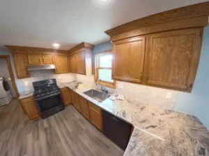 Wide view of Stately’s Akron kitchen refresh with color-matched crown molding and premium stone countertops.