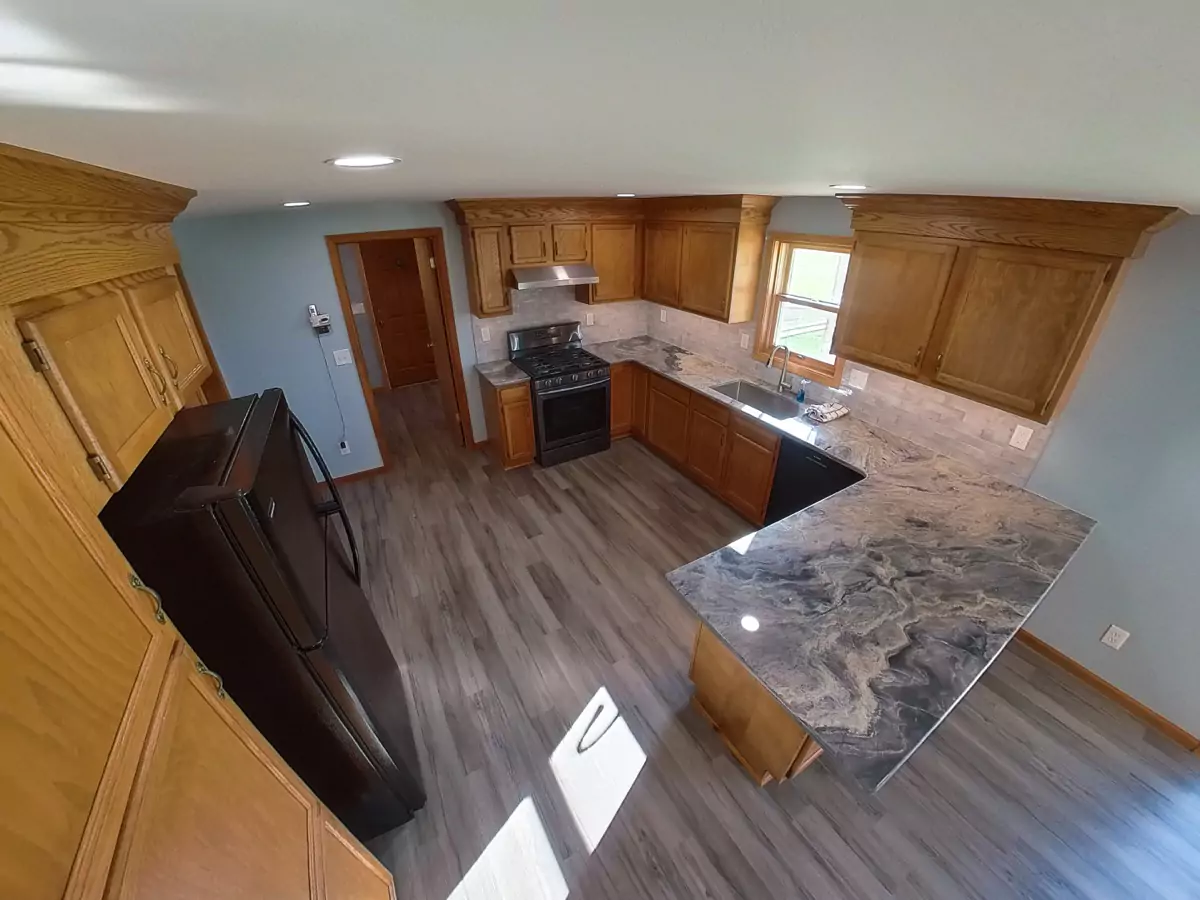 Bright and open Stately kitchen remodel with recessed lighting and premium vinyl plank flooring.