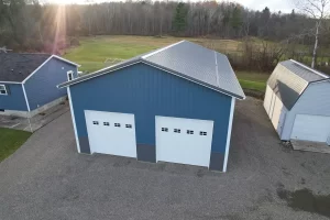 Twilight angle showcasing custom pole barn, white garage doors, and charcoal steel wainscoting. {{brizy_dc_image_alt entityId=