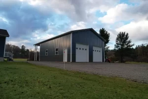Aerial view of completed post-frame pole barn with dual overhead doors in Clarence Center NY.