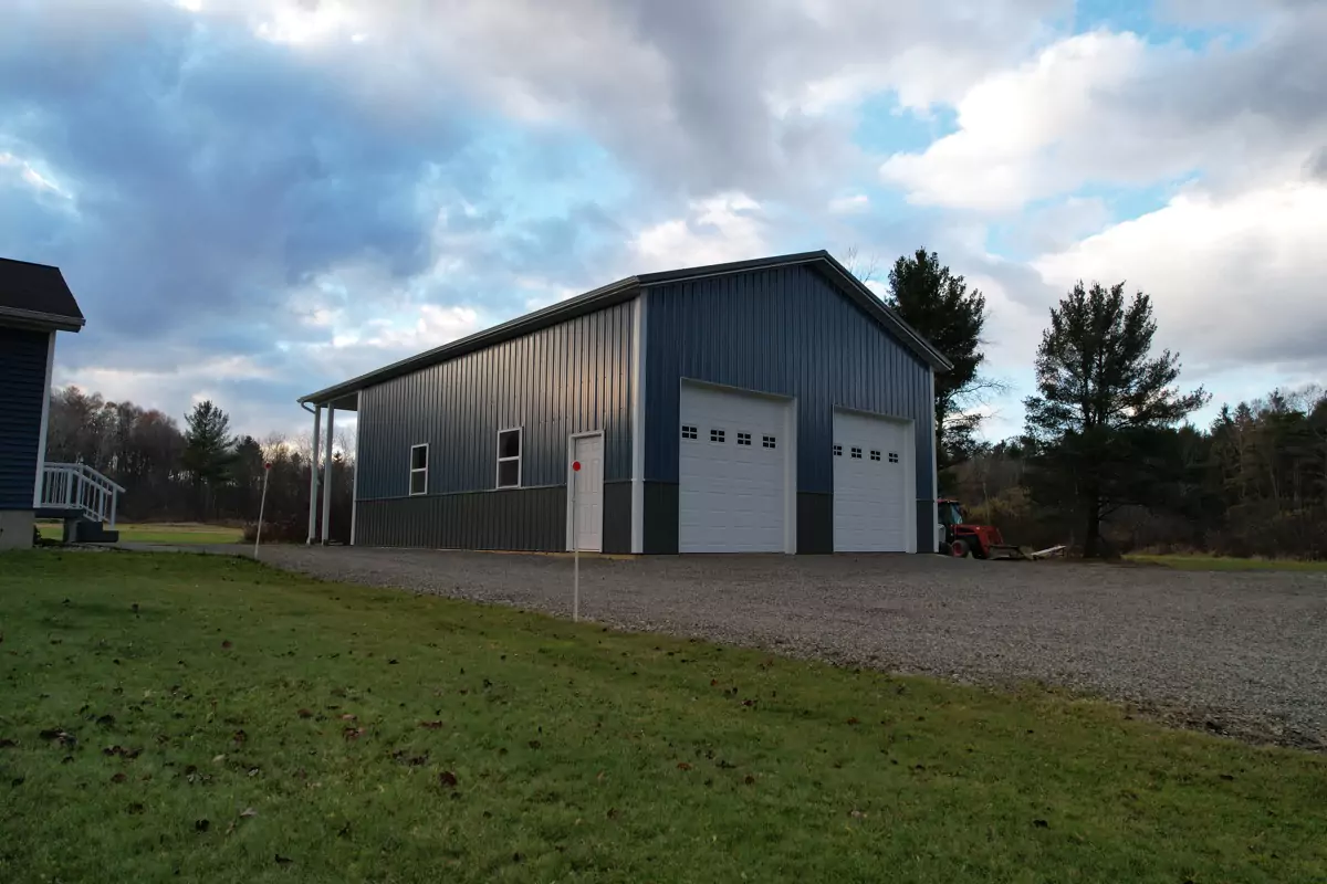 Aerial view of completed post-frame pole barn with dual overhead doors in Clarence Center NY.
