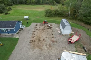 Pre-construction aerial of gravel pad with post hole layout before Stately Builders began pole barn construction.
