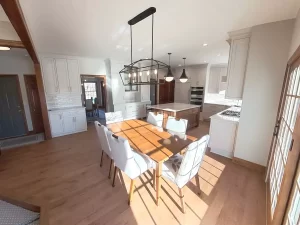 Amherst NY kitchen remodel with built-in buffet, white cabinetry, wood floors, pendant lights, and sunlit dining area.