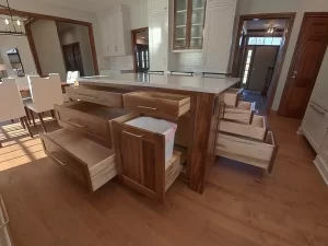 Amherst NY kitchen island with custom pull-out drawers, integrated trash bin, and walnut wood construction for smart storage.