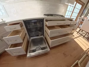 Amherst NY kitchen remodel with pull-out drawers, integrated dishwasher, brass hardware, and subway tile backsplash.