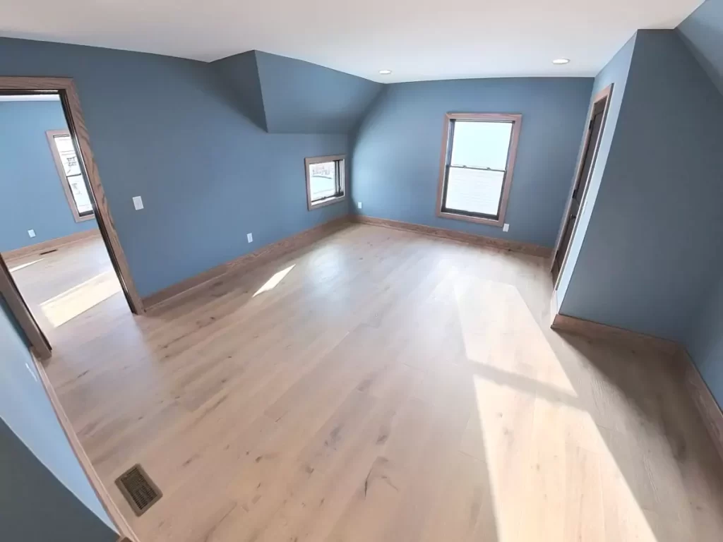 Spacious bonus room with prefinished hardwood floors, natural light, and custom trim in a Buffalo-area home addition.