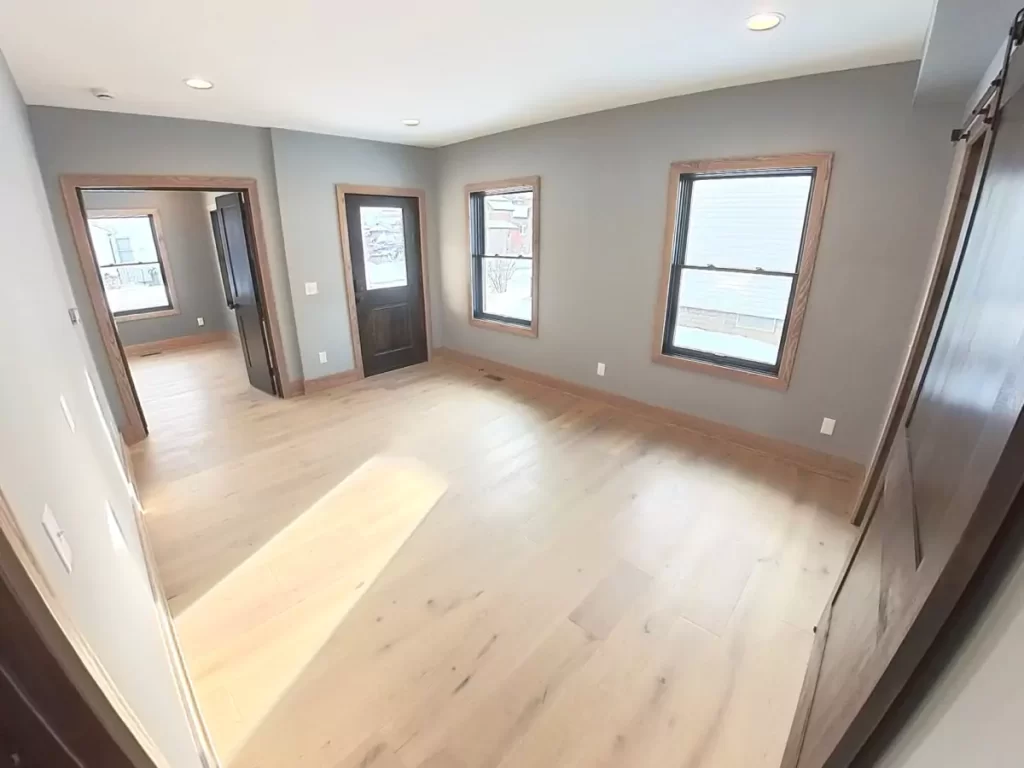 Bright side entry with original front door preserved in Buffalo home remodel, connecting to bedrooms and updated interior layout.
