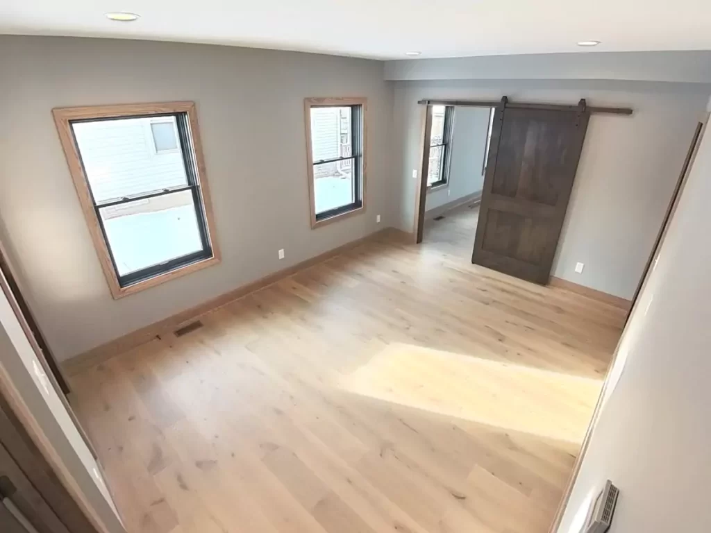 Renovated side entry of historic Buffalo home, featuring sliding barn door and natural light from dual-pane windows.
