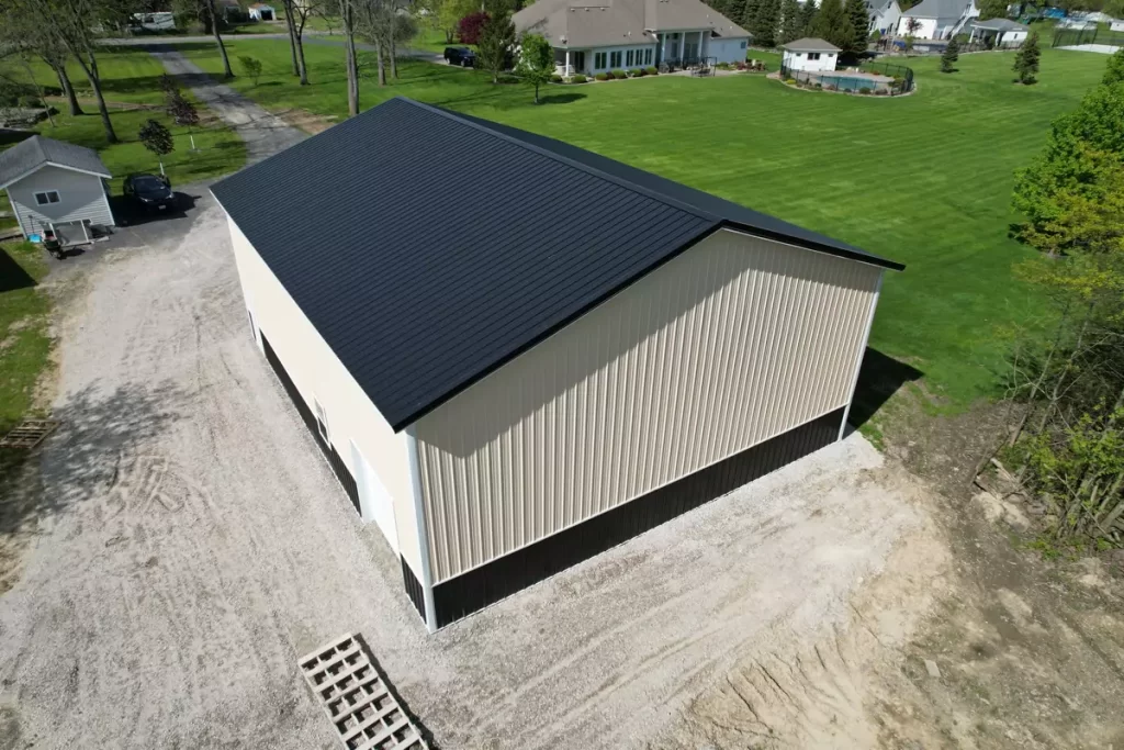 Aerial view of beige and black post-frame garage with metal roof, built by Stately in a residential Amherst NY neighborhood.