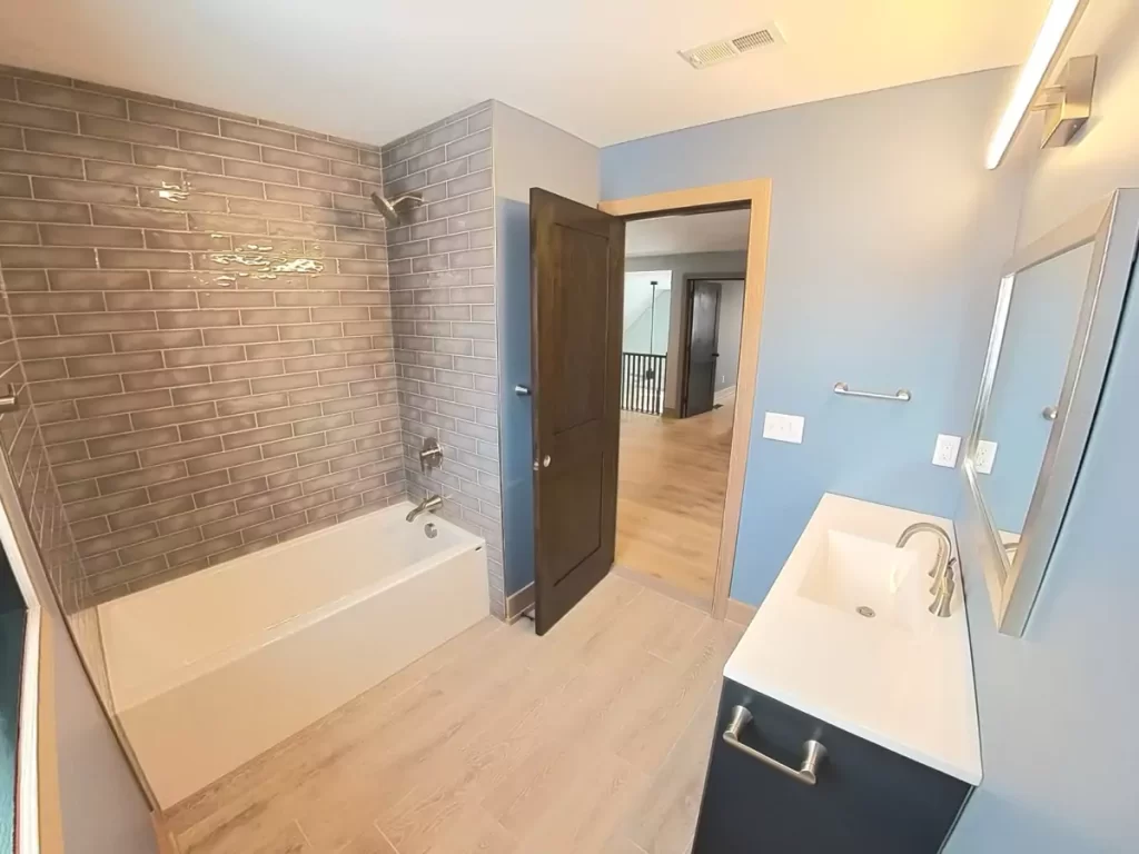 Modern upstairs bathroom in Buffalo remodel with subway tile shower, single vanity, and light blue walls for a clean, bright finish.