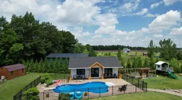 Aerial view of the pool house addition in Akron, NY, showcasing the surrounding landscape and custom millwork details by Stately General Contracting.