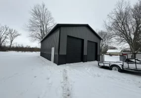 A Stately Pole Barn in East Amherst, NY, showcasing its sharp black and grey color scheme against a snowy backdrop.