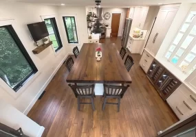 Aerial view of remodeled kitchen and dining area with wooden island and elegant lighting in Amherst, NY by Stately Kitchen and Bath.