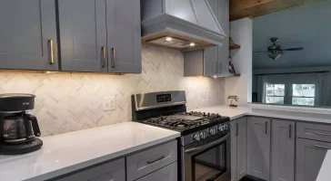 Countertops, range, and range hood. Modern kitchen with natural elements by Stately Kitchen and Bath in Amherst, NY.