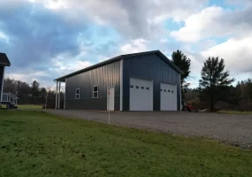 Aerial view of completed post-frame pole barn with dual overhead doors in Clarence Center NY.