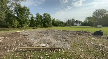 Concrete piers in place for Stately Pole Barn foundation, ensuring durability and stability for the post-frame structure.